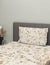 Floral-patterned bedspread and pillow on a bed with a gray headboard.