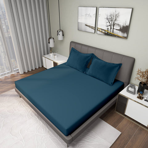 Gres Legion Blue Color Bedsheet With 2 Pillows under a Charcoal Color Bed With Light Lamps on One Side And Photo Frames