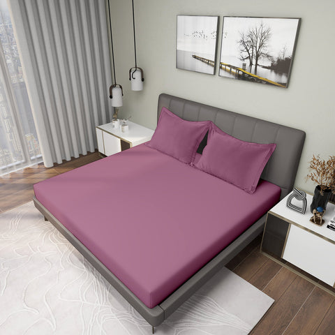 Red Voilet Colour Bedsheet With 2 Pillows on Charcoal Coloured Bed with two photo frames