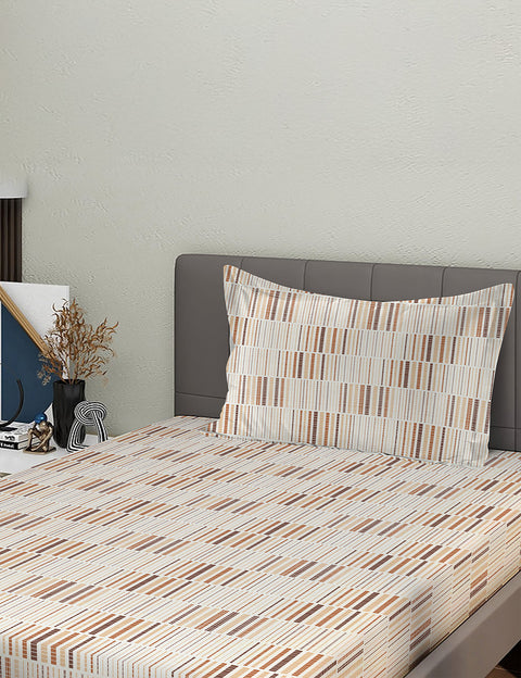 Bed with striped bedding and pillow against a neutral wall
