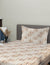 Bed with striped bedding and pillow against a neutral wall