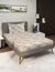 Bedroom with a bed featuring a striped mattress cover, pillows, and a nightstand.