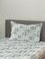 Bed with striped bedding and pillow against a plain wall