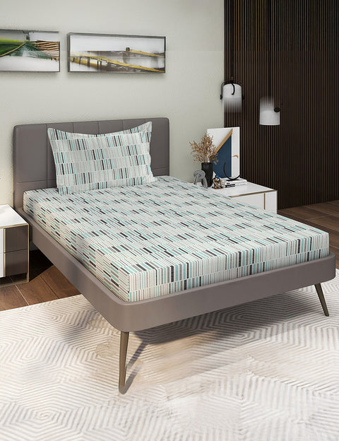 Bed with patterned mattress cover and pillows in a bedroom setting.