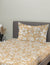 Floral patterned bedspread on a bed with a gray headboard.