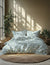 Floral patterned bedding set on a bed with plants and sunlight in the background
