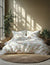 Floral bedding set on a bed with plants and sunlight in the background
