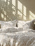 Floral patterned bedding set on a bed with pillows sunlight casting shadow