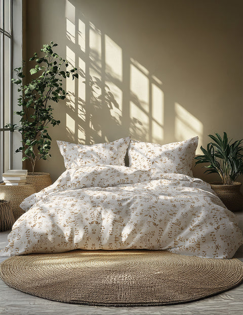 Floral bedding set on a bed with plants and sunlight in the background