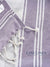 Close-up of a purple and white striped fabric with intricate stitching, featuring the LANE LINEN brand.