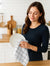 Woman cleaning a plate with a dishcloth in a kitchen