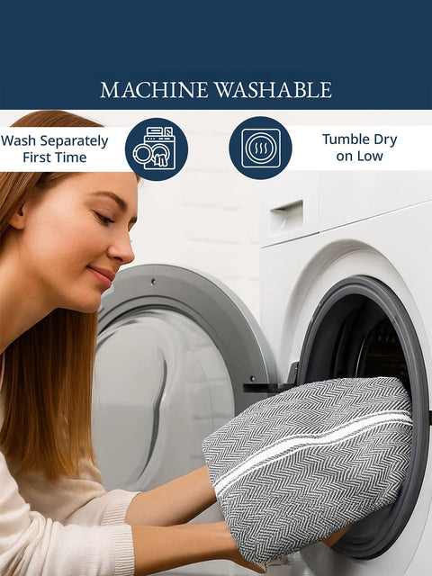 Woman placing a fabric Clothof grey color into a washing machine with washing instructions of washing & tumbling displayed.