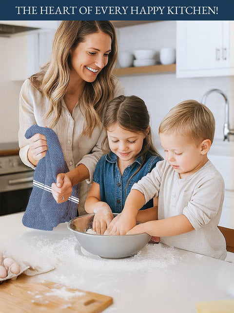 A Woman holding a indigo color kitchen towel  with white background in hand and two children in a kitchen mixing ingredients in a bowl.