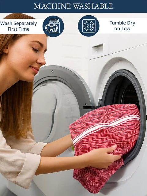 Woman placing a red towel into a washing machine with washing instructions displayed.