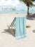 Beach scene with a chair draped and a aqua towel on it and 'Lane Linen' branding.