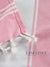 Close-up of a candy pink and white striped towel with tassels, featuring the Lane Linen brand.