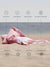 Folded pink towel on sand with text highlighting features like quick dry towels, sand proof, breathable, machine washable, absorbent, compact, versatile, stylish design