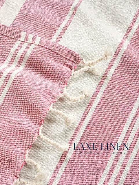 Close-up of pink and white striped fabric with 'Lane Linen' branding.