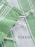 Close-up of green and white checkered fabric with 'Lane Linen' branding.