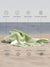 Lime Color towel on sand with text highlighting features like quick dry, sand proof, breathable, machine washable, absorbent, compact, versatile, and stylish design.