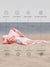 Quartz Pink towel on sand with text highlighting features like quick dry, sand proof, breathable, machine washable, absorbent, compact, versatile, and stylish design.