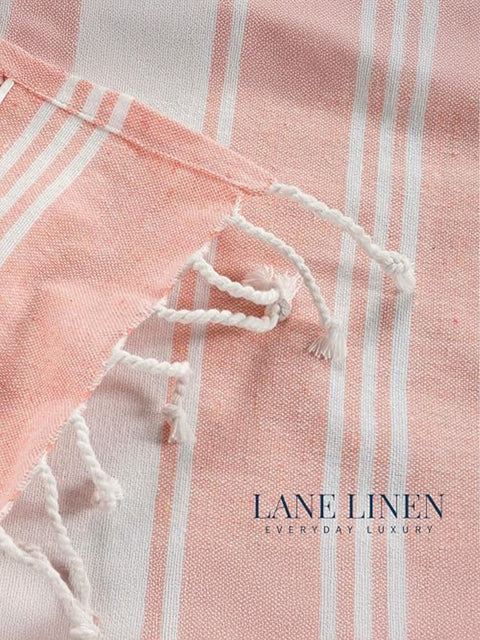 Close-up of pink and white striped fabric with frayed edge, featuring 'Lane Linen' branding 