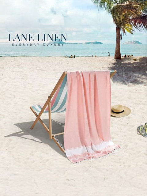 Beach scene with a pink towel draped over a deck chair, palm tree, and 'Lane Linen' branding.