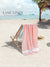 Beach scene with a pink towel draped over a deck chair, palm tree, and 'Lane Linen' branding.