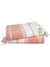 Folded Coral pink and white striped towel with a tag on a white background