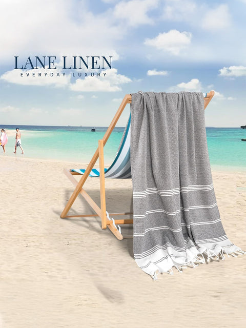 Gray towel draped over a beach chair with a scenic ocean view and 'Lane Linen' branding.