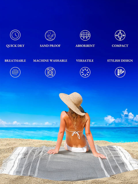 Woman sitting on a beach towel with product features as quick dry, sand proof, absorbent, compact, breatheable,maachine washable, versatile, stylish design