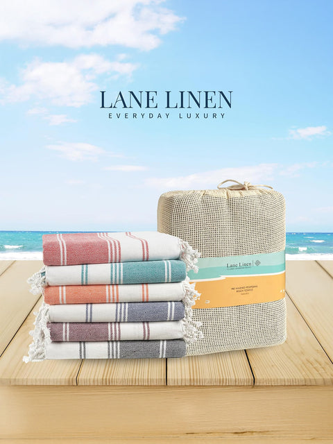 Stack of Lane Linen towels with a woven basket against a beach background