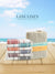 Stack of Lane Linen towels with a woven basket against a beach background