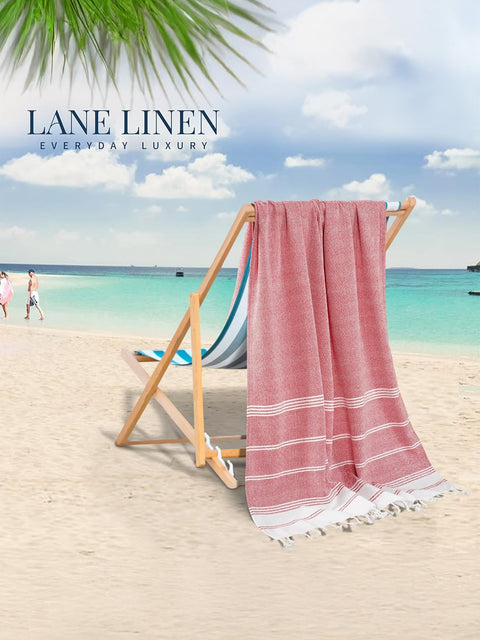 Red Color Beach Towel With White Strips Displayed on A Beach Backgorund hanging on a wooden deck chair
