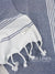 White towel with blue stripes and on a geometric patterned fabric background, featuring the brand 'Lane Linen'.