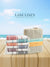Stack of striped towels and a woven basket with 'Lane Linen' branding against a beach background on a wooden surface