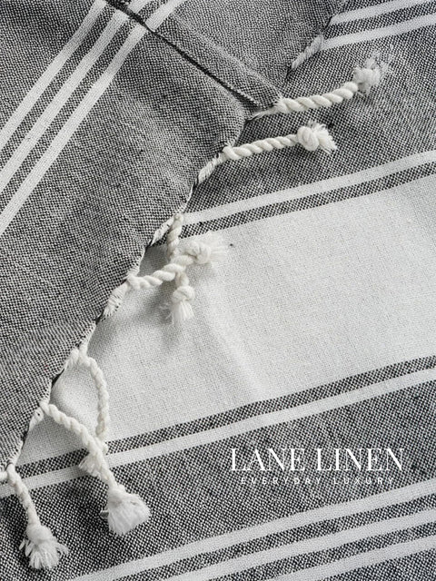 Textured fabric with tassels and stripes, featuring the brand 'Lane Linen