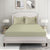 A king-sized sheet with a satin edge and two pillowcases in a bedroom setting, featuring a green stripe pattern on a white background.