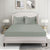 A king-size fitted sheet set with a silver stripe design, displayed on a bed in a room with two framed artworks on the wall and a nightstand with a lamp on the side.