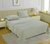 A queen-sized fitted satin sheet set in a Mineral  color with 2 Pillows displayed on a bed with a pair of pillowcases, in a room with a wooden floor and a light gray carpet.