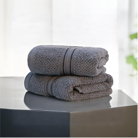 Two Charcoal cotton hand towels are stacked on top of each other, displaying a plush and soft texture.