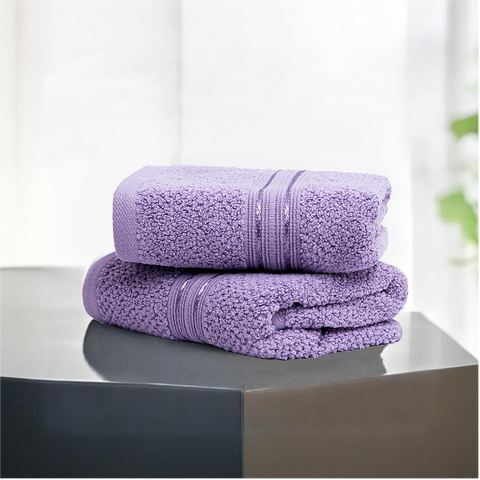 Two folded lavendar-colored cotton hand towels on a dark surface with a light background.