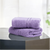 Two folded lavendar-colored cotton hand towels on a dark surface with a light background.