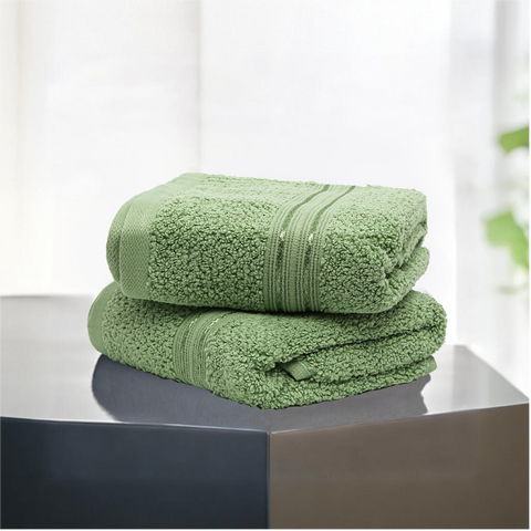 Two green Lane Linen 100% cotton hand towels, highly absorbent, placed on a grey surface with a blurred background.