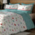  White Multicolor Pattern Bedsheet With 4 Pillows On A Wooden Bed