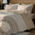 Brown Circle Bedsheet With 4 Pillows On A Wooden Bed