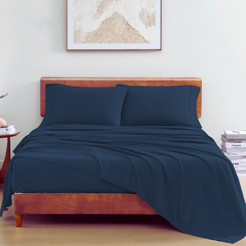 King Sized Bedsheet With 2 Pillows On a Wooden Bed With Photoframe In Background 