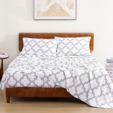 King size bedsheet with 2 pillows on a wooden bed with photoframe in the background